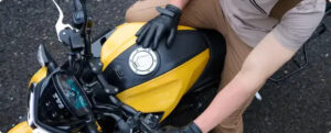 Rider sitting on the yellow TVS Raider 125 2025, showing digital console and fuel tank design.